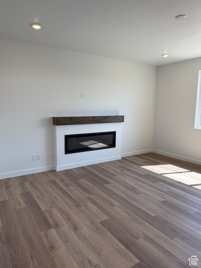 274 N 825 W, Clearfield, UT 84015 - unfurnished living room featuring a glass covered fireplace, wood finished floors, and recessed lighting
