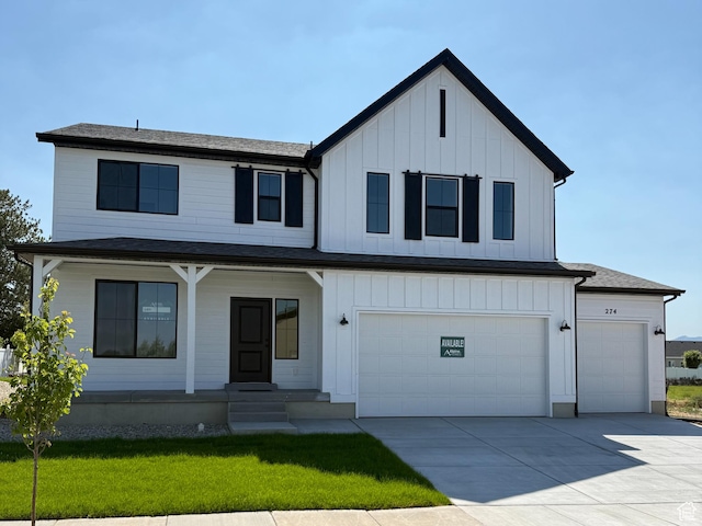 274 N 825 W, Clearfield, UT 84015 - view of front facade with board and batten siding, driveway, a front yard, and a garage