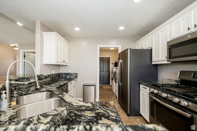 3520 W 2600 N, Plain City, UT 84404 - kitchen featuring appliances with stainless steel finishes, washer and dryer, white cabinetry, dark stone counters, and recessed lighting