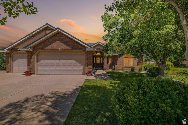 3520 W 2600 N, Plain City, UT 84404 - view of front facade with driveway, a garage, brick siding, and a lawn