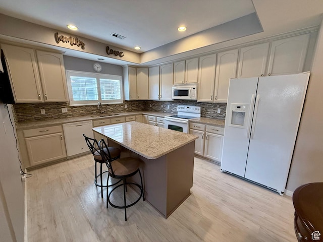 7089 S Brittany Town Dr, West Jordan, UT 84084 - kitchen with white appliances, light wood finished floors, tasteful backsplash, light stone countertops, and recessed lighting