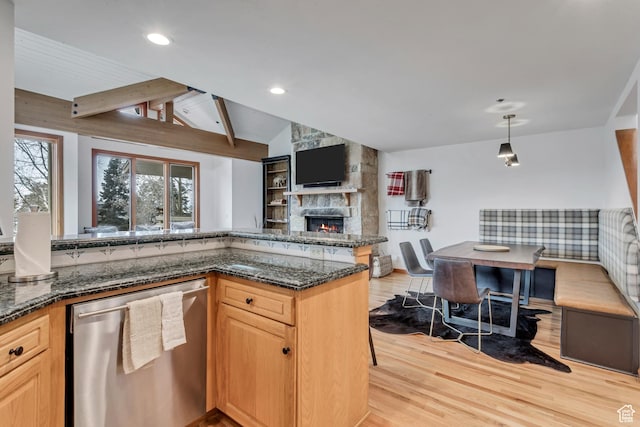 7525 Ridge Dr Unit 19, Park City, UT 84060 - kitchen featuring stainless steel dishwasher, light wood finished floors, a fireplace, open floor plan, and dark stone countertops