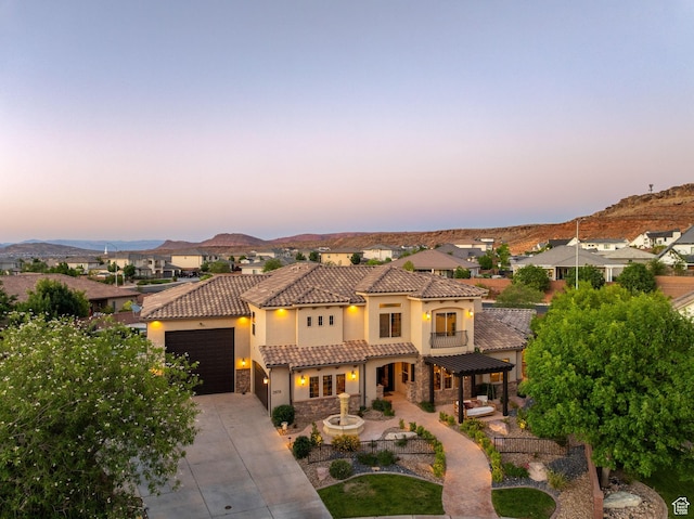 2979 E 3610th Cir S, St George, UT 84790 - mediterranean / spanish-style house featuring stone siding, a tiled roof, concrete driveway, stucco siding, and a pergola