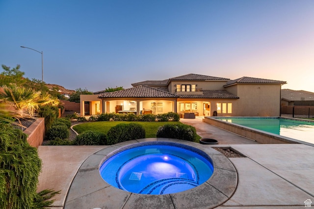 2979 E 3610th Cir S, St George, UT 84790 - rear view of house featuring an in-ground hot tub, an outdoor pool, a tile roof, stucco siding, and a patio area