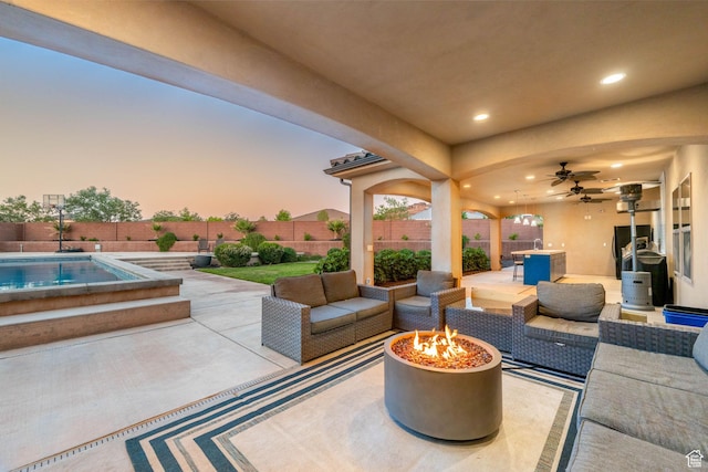 2979 E 3610th Cir S, St George, UT 84790 - patio terrace at dusk featuring a patio, a fenced backyard, ceiling fan, and an outdoor living space with a fire pit