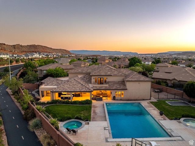 2979 E 3610th Cir S, St George, UT 84790 - pool at dusk with an in-ground hot tub, a fenced backyard, a patio, a residential view, and a mountain view