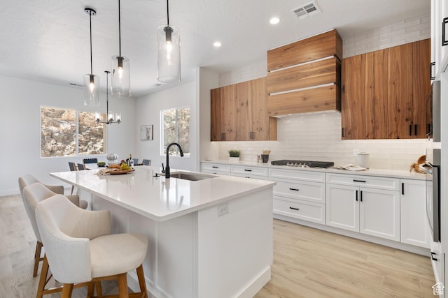 794 S 1690 W, Hurricane, UT 84737 - kitchen featuring stainless steel gas stovetop, light countertops, backsplash, a center island with sink, and white cabinetry