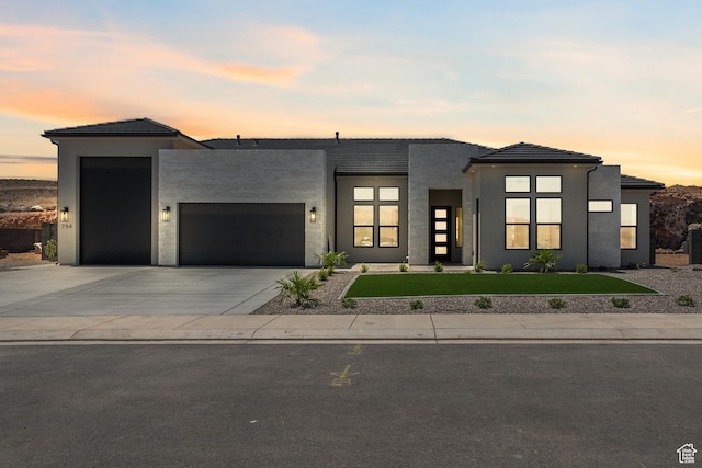 794 S 1690 W, Hurricane, UT 84737 - modern home featuring a garage, a front yard, concrete driveway, stucco siding, and a tile roof