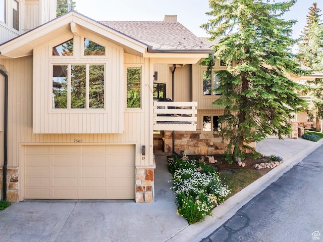 7560 Ridge Dr Unit 10, Park City, UT 84060 - view of front facade featuring stone siding, an attached garage, roof with shingles, and concrete driveway