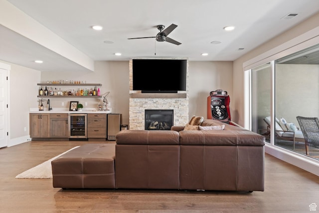 11422 N Vantage Ln Unit 69, Hideout, UT 84036 - living room featuring wine cooler, wet bar, ceiling fan, light wood-style flooring, and a fireplace