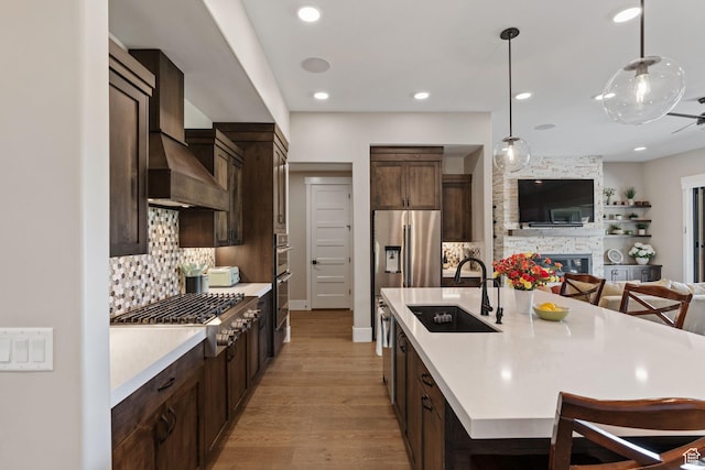 11422 N Vantage Ln Unit 69, Hideout, UT 84036 - kitchen with dark brown cabinets, light countertops, decorative backsplash, stainless steel appliances, and wall chimney exhaust hood