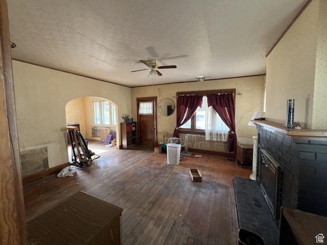 72 W 200 N, Price, UT 84501 - living area with a brick fireplace, arched walkways, a ceiling fan, hardwood / wood-style floors, and a textured ceiling