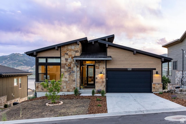 11795 N Star Gazer Cir, Hideout, UT 84036 - modern home featuring stone siding, an attached garage, concrete driveway, and a mountain view