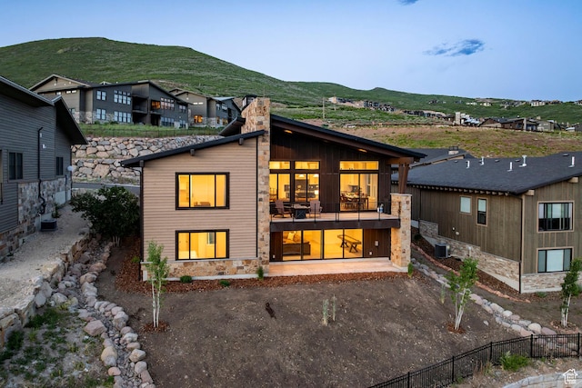 11795 N Star Gazer Cir, Hideout, UT 84036 - rear view of house with a chimney, a mountain view, stone siding, and a balcony