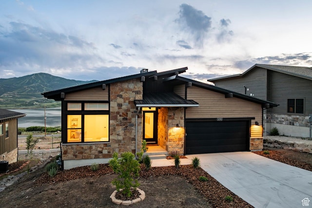 11795 N Star Gazer Cir, Hideout, UT 84036 - contemporary house featuring stone siding, a garage, concrete driveway, and a metal roof