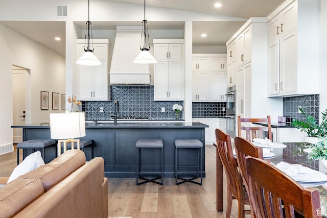 11795 N Star Gazer Cir, Hideout, UT 84036 - kitchen with premium range hood, light wood-style flooring, white cabinets, backsplash, and recessed lighting