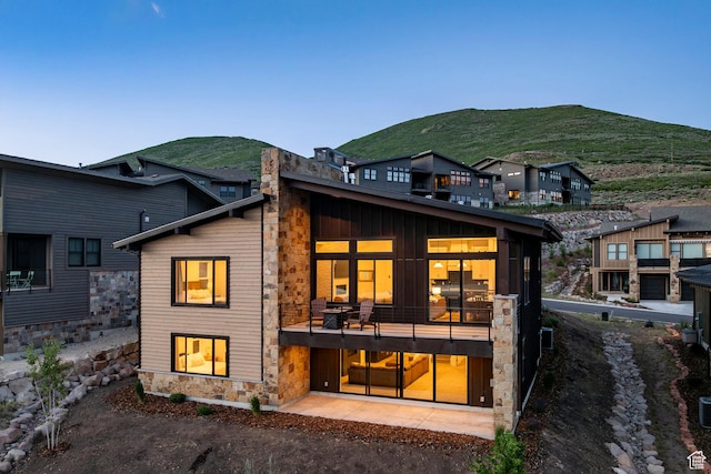 11795 N Star Gazer Cir, Hideout, UT 84036 - rear view of house with stone siding, a mountain view, and a balcony