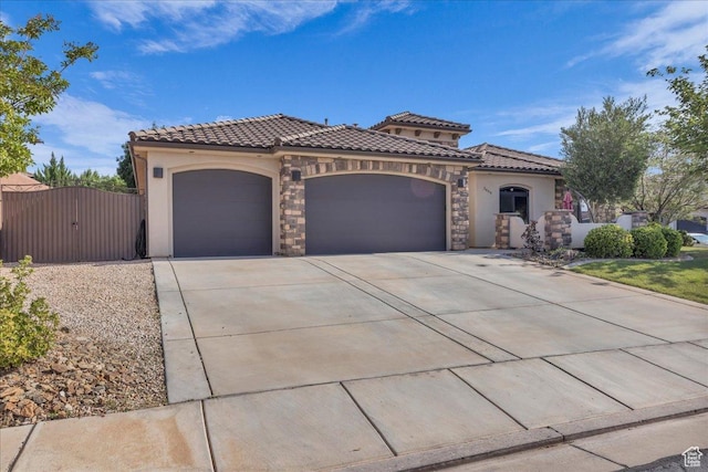2644 E 3800 S, St George, UT 84790 - mediterranean / spanish-style house featuring a garage, stucco siding, a tiled roof, a gate, and driveway