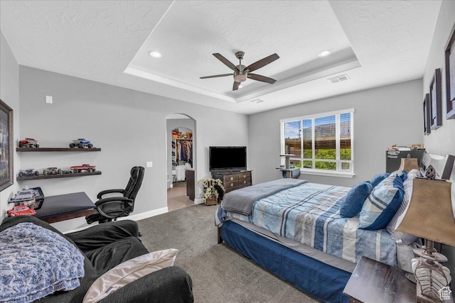 2644 E 3800 S, St George, UT 84790 - carpeted bedroom featuring a tray ceiling, arched walkways, ceiling fan, a spacious closet, and recessed lighting