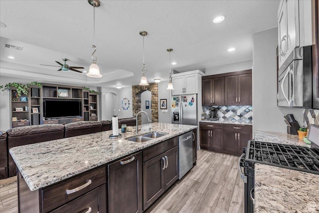 2644 E 3800 S, St George, UT 84790 - kitchen with appliances with stainless steel finishes, open floor plan, ceiling fan, arched walkways, and dark brown cabinetry