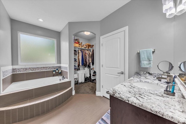2644 E 3800 S, St George, UT 84790 - bathroom featuring a garden tub, double vanity, a walk in closet, and wood finished floors