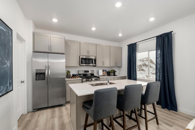 1813 E Bison Dr N Unit B213, Eagle Mountain, UT 84005 - kitchen featuring stainless steel appliances, gray cabinets, light wood-type flooring, a center island with sink, and recessed lighting