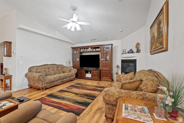3430 Red Butte Dr, Santa Clara, UT 84765 - living room featuring vaulted ceiling, light wood-style flooring, ceiling fan, and a glass covered fireplace