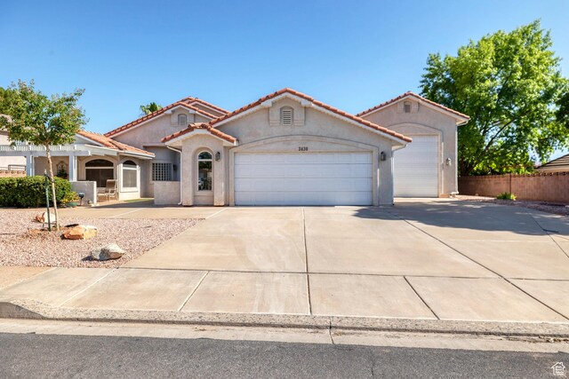 3430 Red Butte Dr, Santa Clara, UT 84765 - mediterranean / spanish-style house featuring a garage, concrete driveway, a tile roof, and stucco siding