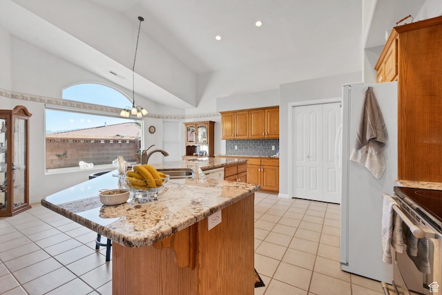 3430 Red Butte Dr, Santa Clara, UT 84765 - kitchen with white appliances, a breakfast bar area, light tile patterned floors, brown cabinets, and decorative backsplash