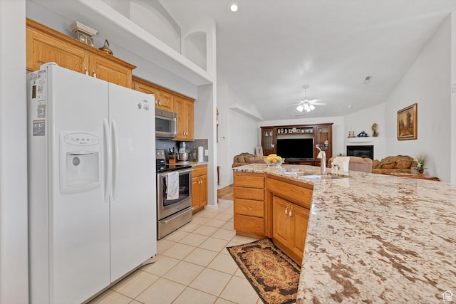 3430 Red Butte Dr, Santa Clara, UT 84765 - kitchen with stainless steel appliances, a glass covered fireplace, ceiling fan, open floor plan, and light tile patterned floors