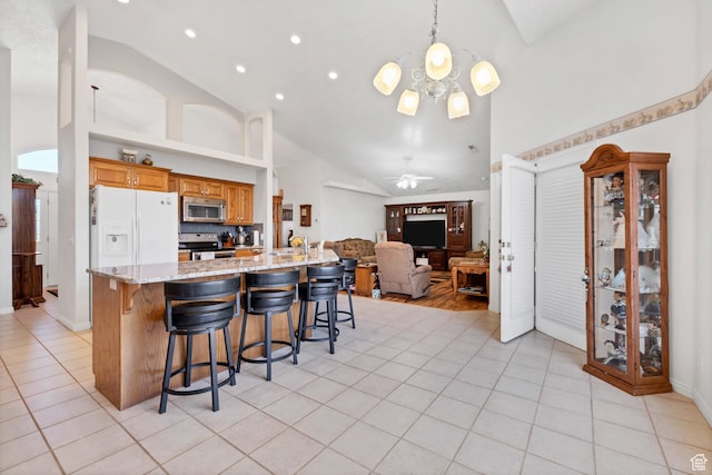 3430 Red Butte Dr, Santa Clara, UT 84765 - kitchen with stainless steel appliances, high vaulted ceiling, light tile patterned flooring, a breakfast bar, and open floor plan