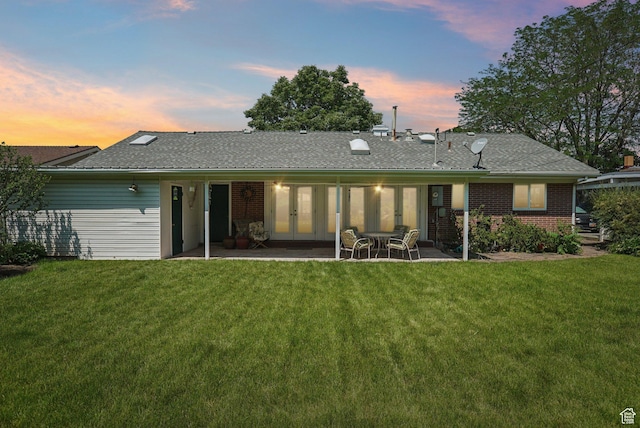 4199 S Monarch Way, Salt Lake City, UT 84124 - back of property at dusk with french doors, a lawn, a patio area, and brick siding