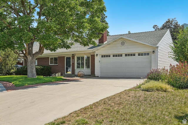 4199 S Monarch Way, Salt Lake City, UT 84124 - view of front of home with an attached garage, driveway, a chimney, a front yard, and brick siding
