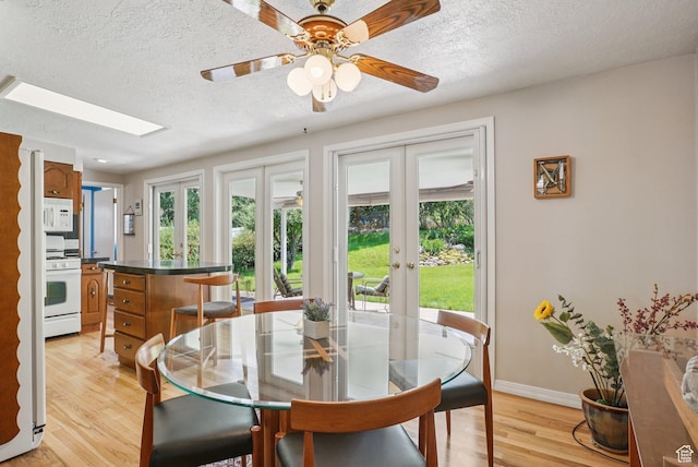 4199 S Monarch Way, Salt Lake City, UT 84124 - dining space featuring french doors, healthy amount of natural light, light wood-style floors, a textured ceiling, and a skylight