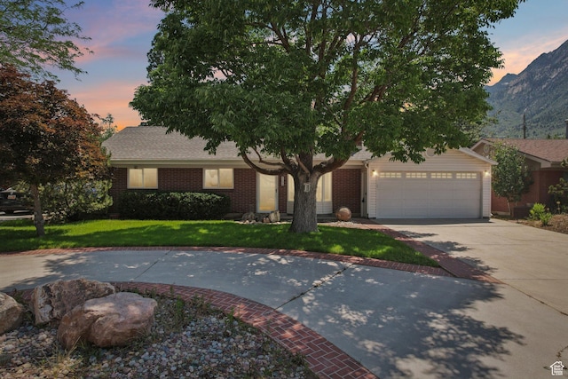 4199 S Monarch Way, Salt Lake City, UT 84124 - view of front of property with concrete driveway, a yard, a garage, brick siding, and a mountain view