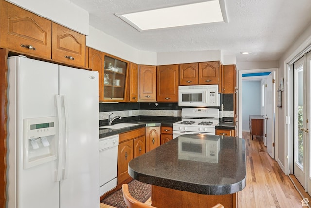 4199 S Monarch Way, Salt Lake City, UT 84124 - kitchen with white appliances, dark countertops, brown cabinetry, light wood-type flooring, and a textured ceiling