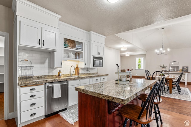 727 S Main St, Mapleton, UT 84664 - kitchen with dishwasher, dark wood-style floors, a center island, backsplash, and a kitchen breakfast bar
