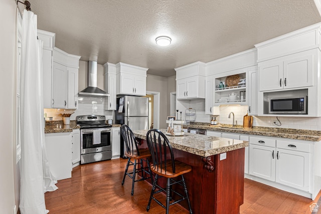 727 S Main St, Mapleton, UT 84664 - kitchen featuring appliances with stainless steel finishes, wall chimney exhaust hood, decorative backsplash, dark wood-type flooring, and a textured ceiling