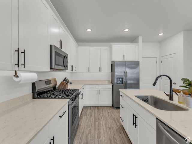 937 W Purpledisk Ct, Saratoga Springs, UT 84045 - kitchen with stainless steel appliances, white cabinets, light wood finished floors, light stone countertops, and recessed lighting