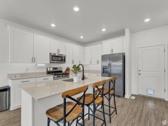 937 W Purpledisk Ct, Saratoga Springs, UT 84045 - kitchen featuring stainless steel appliances, light wood-style flooring, an island with sink, white cabinets, and recessed lighting