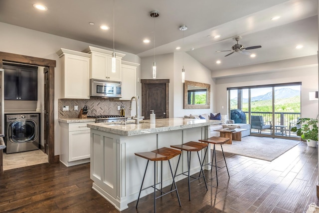 1161 W Wintercress Trl W Unit 27F, Kamas, UT 84036 - kitchen featuring washer / dryer, stainless steel microwave, open floor plan, dark wood-type flooring, and lofted ceiling