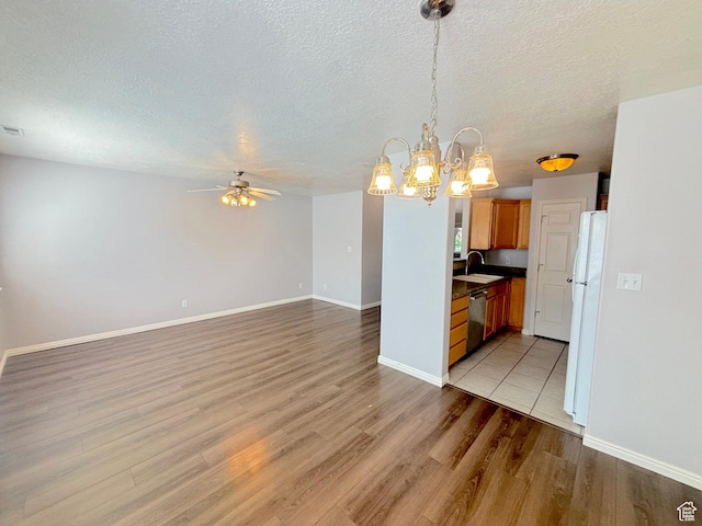 10521 S Sage Flats Way S, Jordan, UT 84009 - kitchen featuring freestanding refrigerator, ceiling fan, light wood finished floors, stainless steel dishwasher, and a chandelier