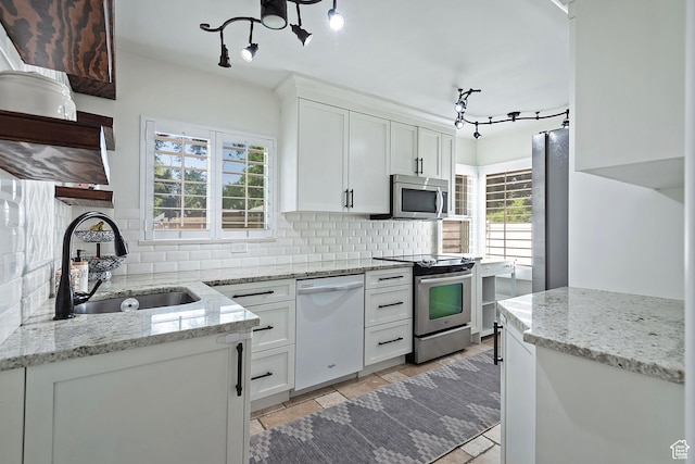 2090 E Crystal Ave S, Salt Lake City, UT 84109 - kitchen with appliances with stainless steel finishes, backsplash, white cabinets, and light stone countertops