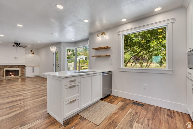 1040 E 900 N, Orem, UT 84097 - kitchen with stainless steel appliances, a peninsula, ceiling fan, white cabinets, and light wood finished floors