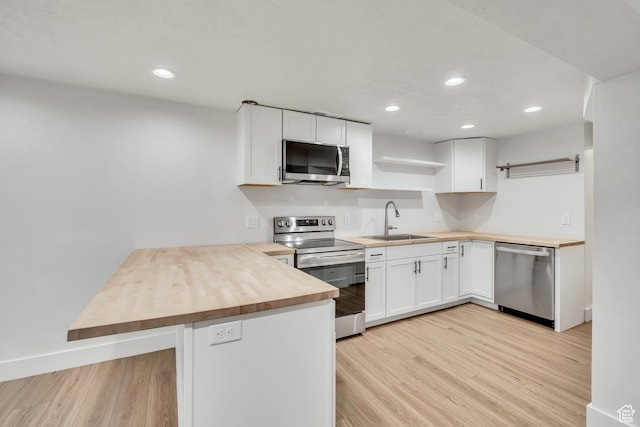 1040 E 900 N, Orem, UT 84097 - kitchen with appliances with stainless steel finishes, butcher block counters, open shelves, a peninsula, and light wood-style floors