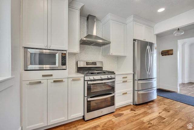 1040 E 900 N, Orem, UT 84097 - kitchen featuring appliances with stainless steel finishes, wall chimney range hood, backsplash, light wood-style flooring, and light countertops