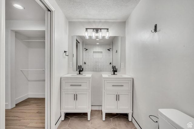1040 E 900 N, Orem, UT 84097 - bathroom with two vanities, a shower, a textured ceiling, tile patterned flooring, and a chandelier