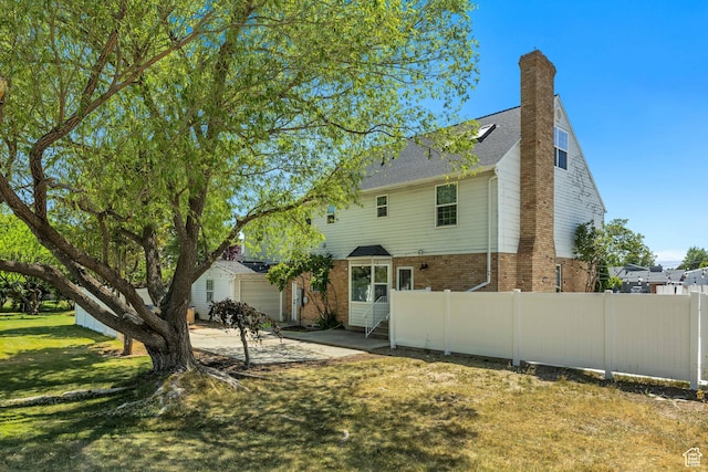 1040 E 900 N, Orem, UT 84097 - back of property with brick siding, an attached garage, a patio area, a chimney, and concrete driveway