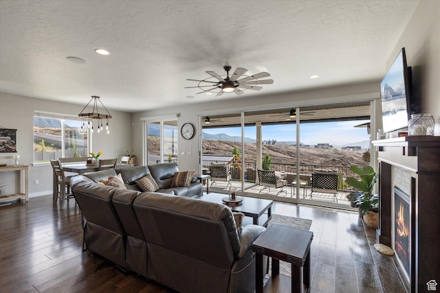 1414 S 790 E, Salem, UT 84653 - living area featuring a lit fireplace, dark wood finished floors, ceiling fan, a textured ceiling, and a chandelier