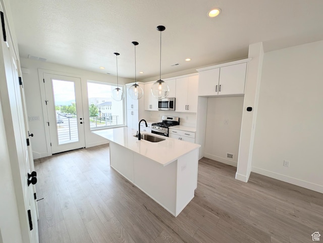 10634 S Cardinal Park Rd W Unit 148, South Jordan, UT 84009 - kitchen with stainless steel appliances, light wood finished floors, recessed lighting, light countertops, and a kitchen island with sink